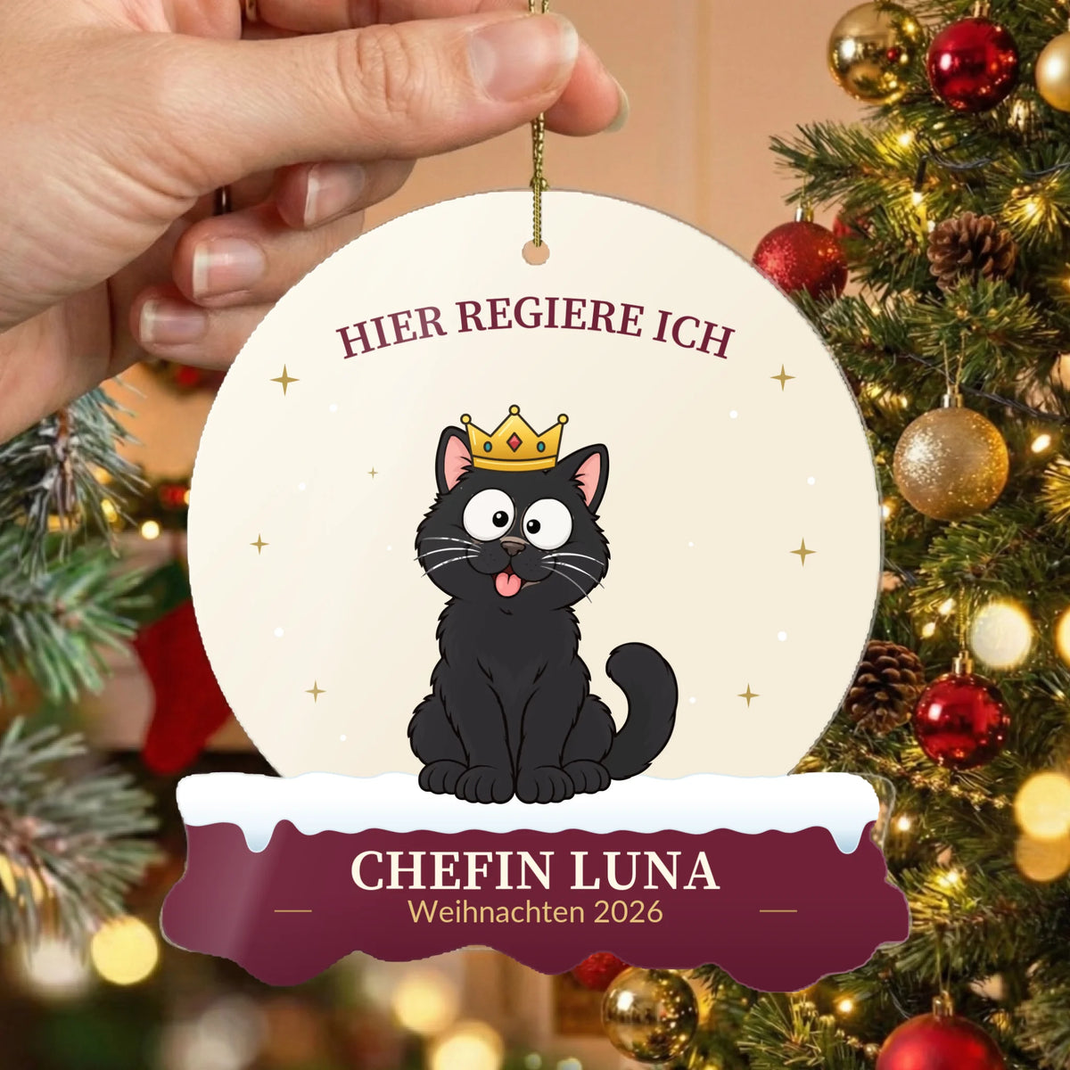 Christbaumschmuck „Hier regiere ich“ mit Katze vor dem geschmückten Weihnachtsbaum