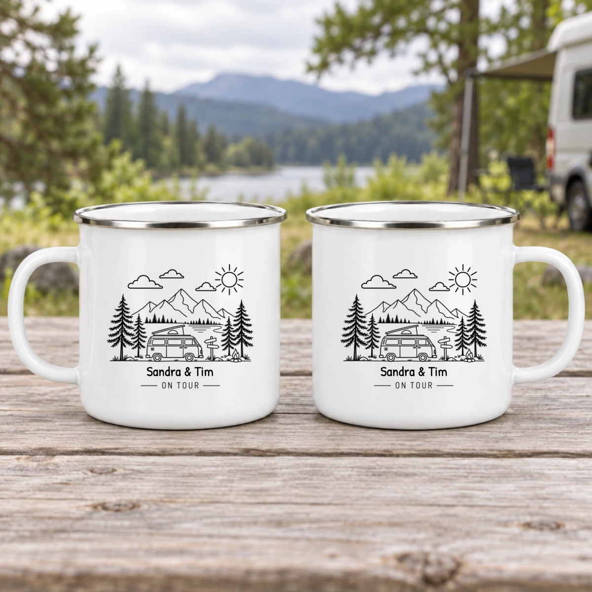 Emaille-Tasse „Camping-Freude“ auf einem Holztisch vor Bergsee und Wohnmobil