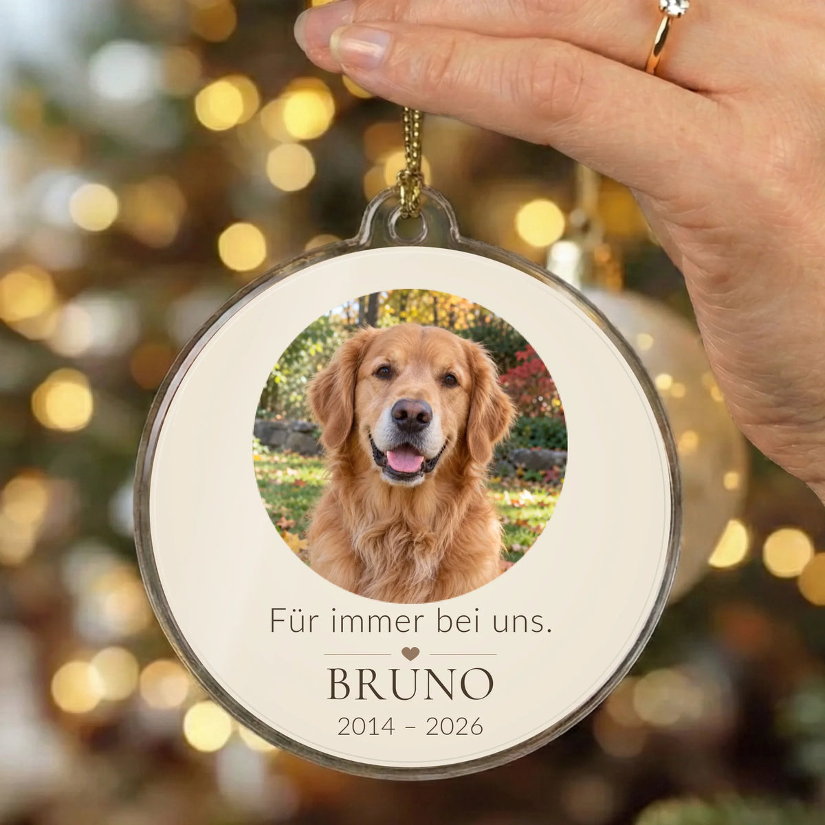 Christbaumschmuck „Für immer bei uns.“ mit Tierfoto und Namen vor Weihnachtslichtern