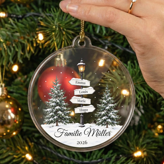 Personalisierter Acrylglas-Christbaumschmuck Laternenweg Familie mit vier Namen, Wunschtext und Jahr in der Hand vor einem Weihnachtsbaum