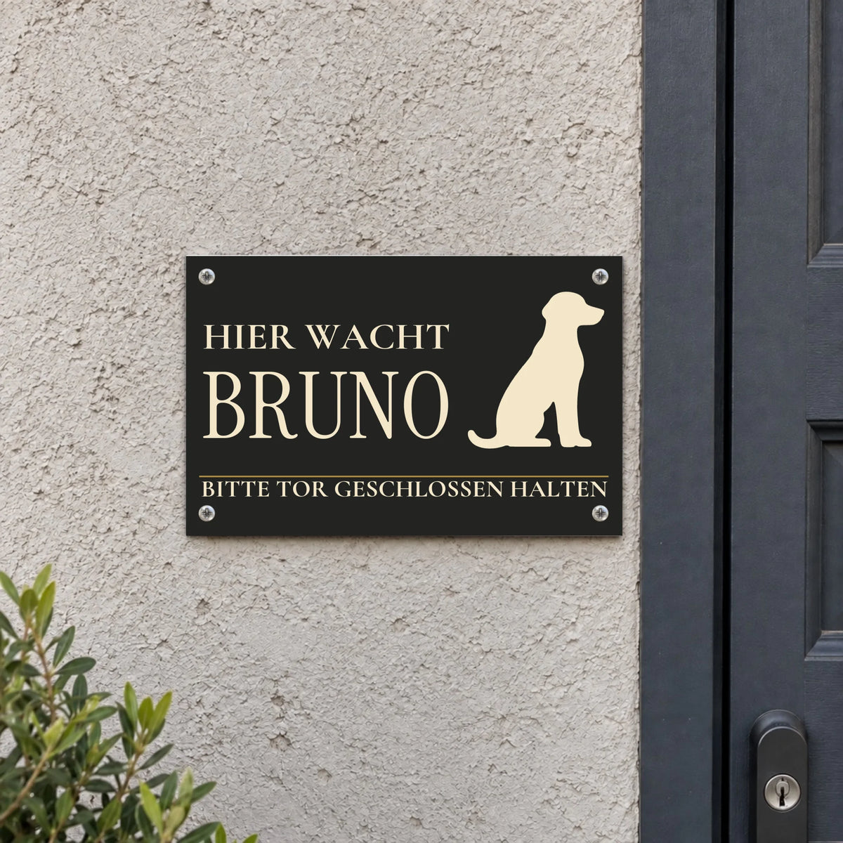 Dunkles Hundeschild „Hier wacht Bruno“ mit Hunde-Silhouette und persönlichem Namen an einer Wand