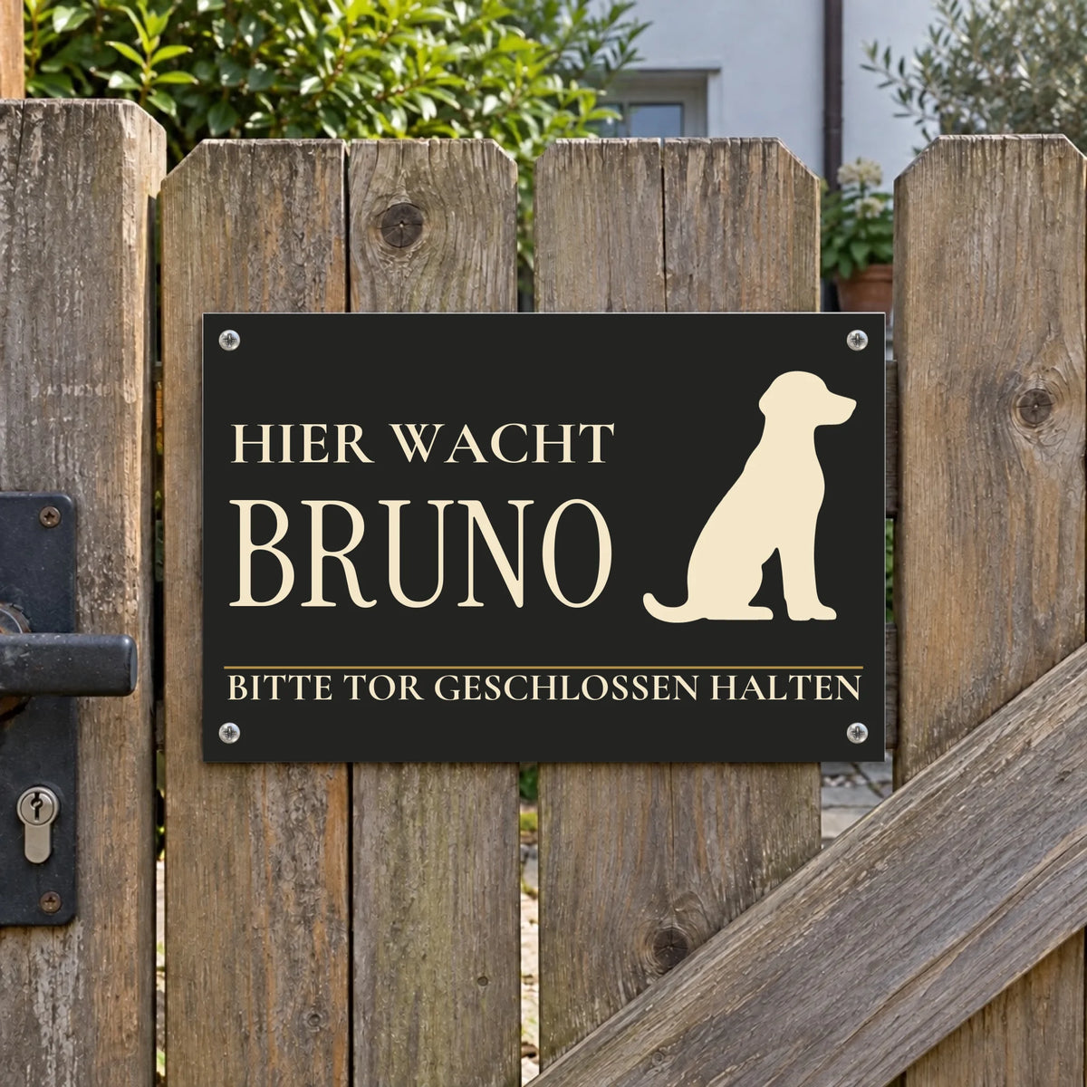 Dunkles Hundeschild „Hier wacht Bruno“ mit Hunde-Silhouette und persönlichem Namen am Holztor